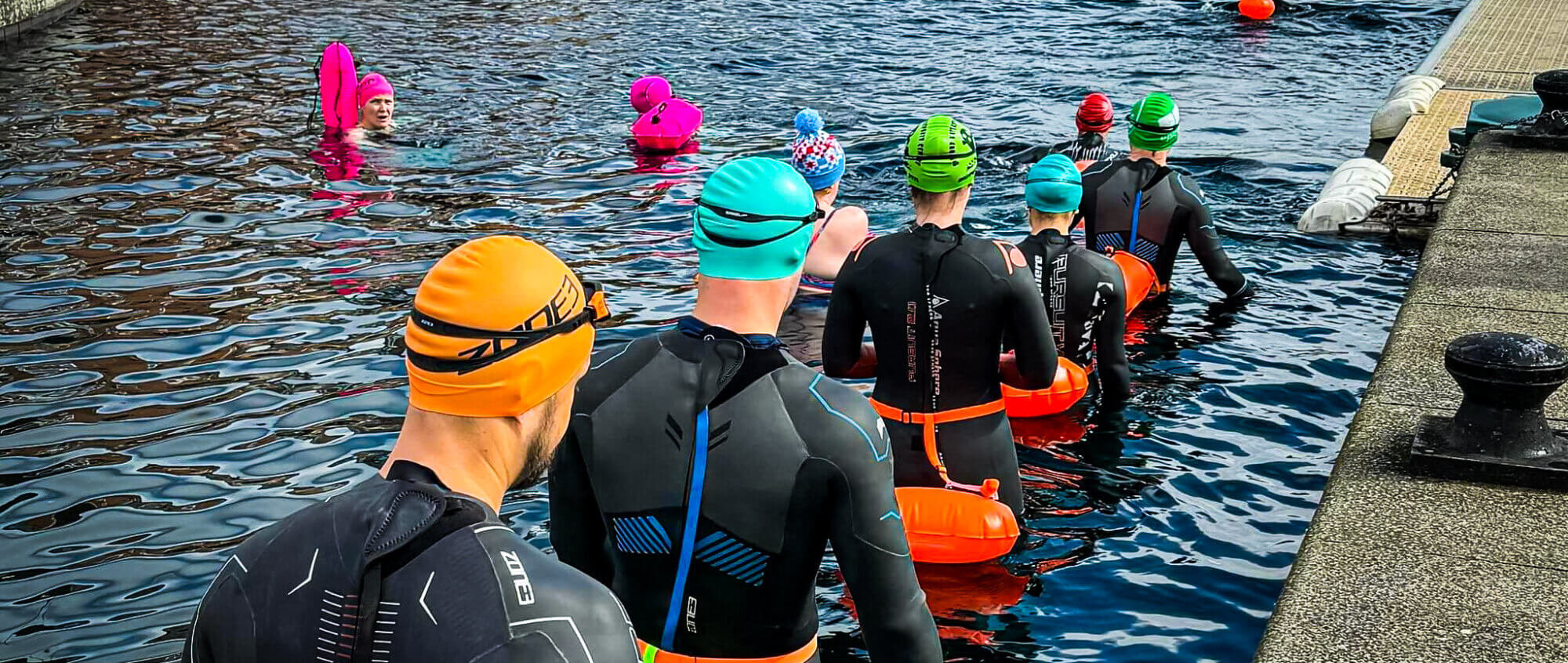 People entering water for open water swimming session